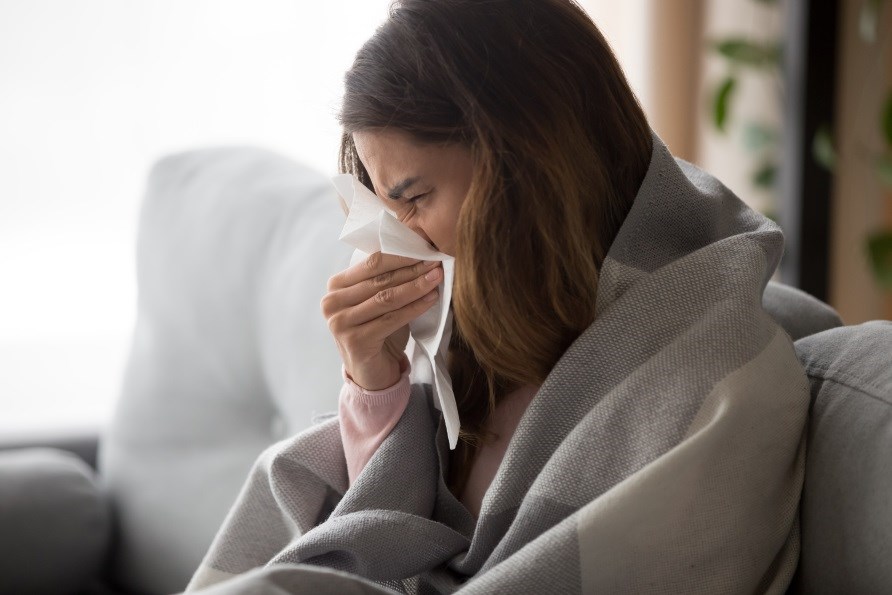 Woman with a cold blows her nose.